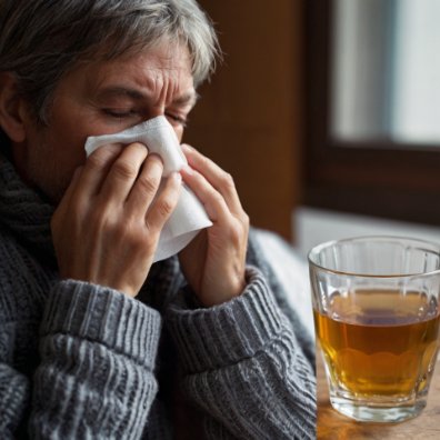 a man blowing his nose into a tissue